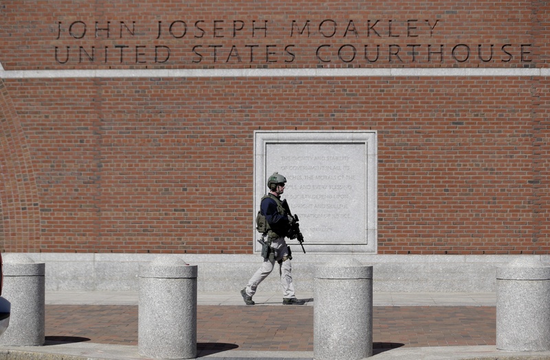 A law enforcement officer wearing tactical gear stands guard outside the John Joseph Moakley Federal Courthouse, which was evacuated Wednesday in Boston.
