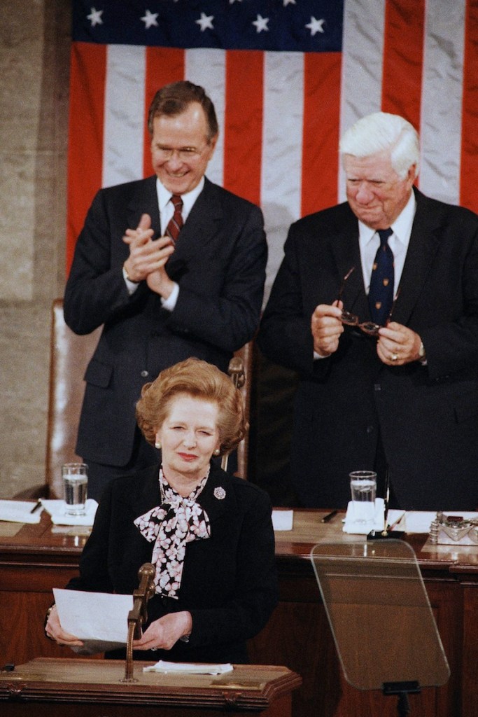 In a Feb. 20, 1985 file photo, British Prime Minister Margaret Thatcher is applauded by Vice President George Bush, left, as House Speaker Thomas P. O'Neill, Jr. looks on just before she addressed a joint meeting of the U.S. Congress, in Washington. Thatchers former spokesman, Tim Bell, said that the former British Prime Minister Margaret Thatcher had died Monday morning, April 8, 2013, of a stroke. She was 87. (AP Photo/Bob Daugherty, File) Authority Looking Away Standing Smiling Applauding