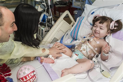 Darryl Warren and Lee Young-mi visit their 2-year-old daughter, Hannah Warren, in a post-op room at the Children's Hospital of Illinois in Peoria after she received a new windpipe. She is the youngest patient ever to get the experimental treatment.