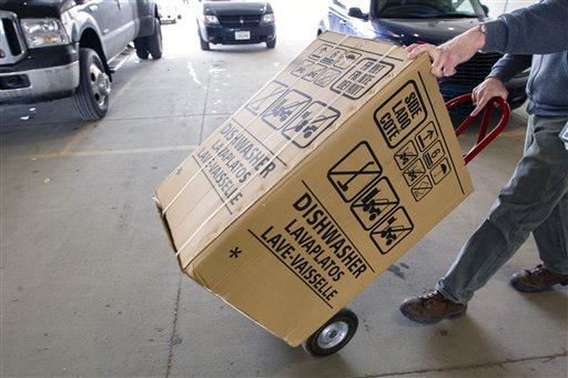 An employee carts a dishwasher to a customer's vehicle recently at Nebraska Furniture Mart in Omaha, Neb.