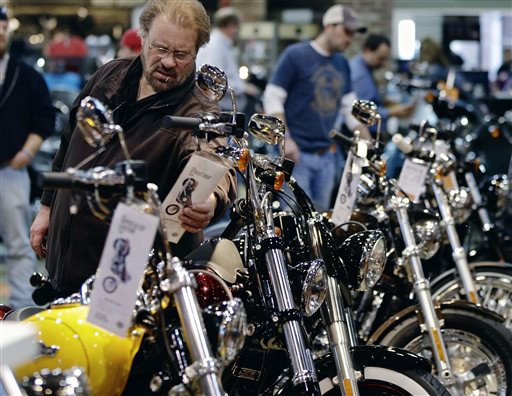 A man examines the price tag on a motorcycle at the Dillon Brothers Harley Davidson dealership in Omaha, Neb. Americans appeared to shrug off a tax increase at the start of the year and spent more in January and February, powered by a stronger job market.