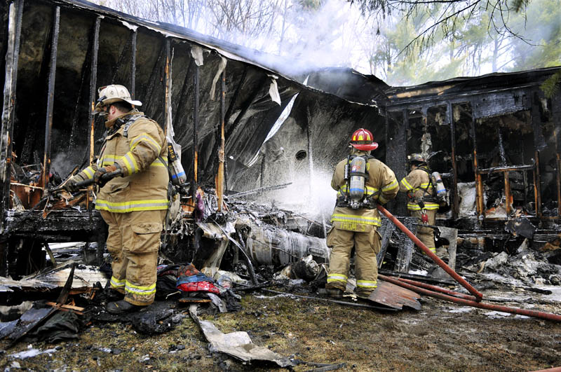 Firefighters extinguish a fire that destroyed a home in Monmouth Monday. Firefighters from several communities arrived at the residence Back Street to discover fire emerging from every corner. No injuries were reported, according to firefighters.
