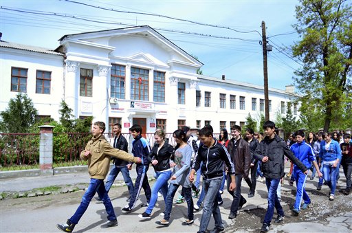 Schoolchildren march in front of a school where Tamerlan Tsarnaev, studied, in the small Kyrgyz city of Tokmok east of the country's capital of Bishkek.