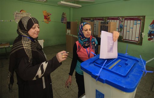 An Iraqi woman casts her ballot at a polling center during the country's provincial elections in Baghdad, Iraq, on Saturday. Polls opened amid tight security for regional elections.