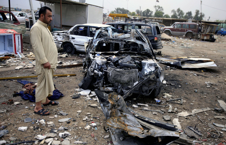 An Iraqi man inspects the aftermath of a car bomb attack at a used car dealer in eastern Baghdad, Iraq, on Tuesday. Violence is on the rise with the approach of Saturday's elections, the country's first since the 2011 U.S. troop withdrawal.