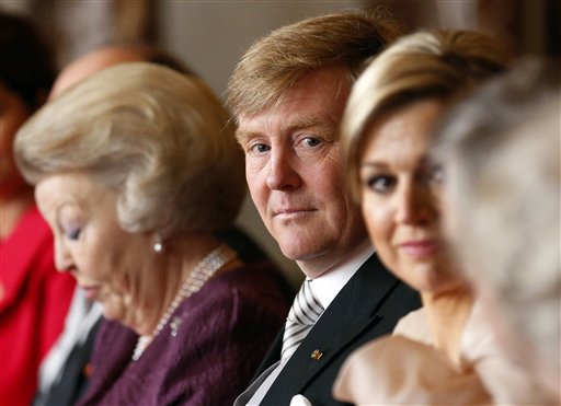 Dutch Queen Beatrix, left, looks down as she prepares to sign the Act of Abdication in favour of her son, Prince Willem-Alexander, center, who sits next to his wife Princess Maxima in the Mozeszaal or Mozes hall of the Royal Palace in Amsterdam, The Netherlands on Tuesday. A million people were expected to descend on the Dutch capital for a huge street party to celebrate the first new Dutch monarch in 33 years.