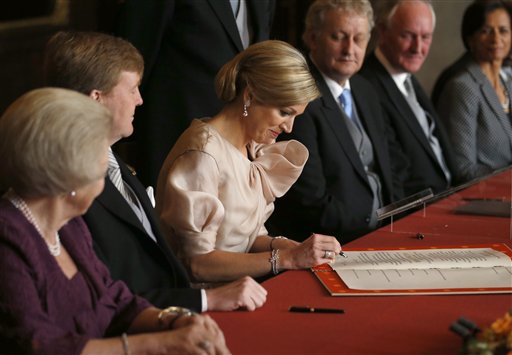 Queen Maxima, right, signs the Act of Abdication after it was signed by King Willem-Alexander, centre, and Queen Beatrix, left, in the Mozeszaal or Mozes hall of the Royal Palace in Amsterdam on Tuesday.