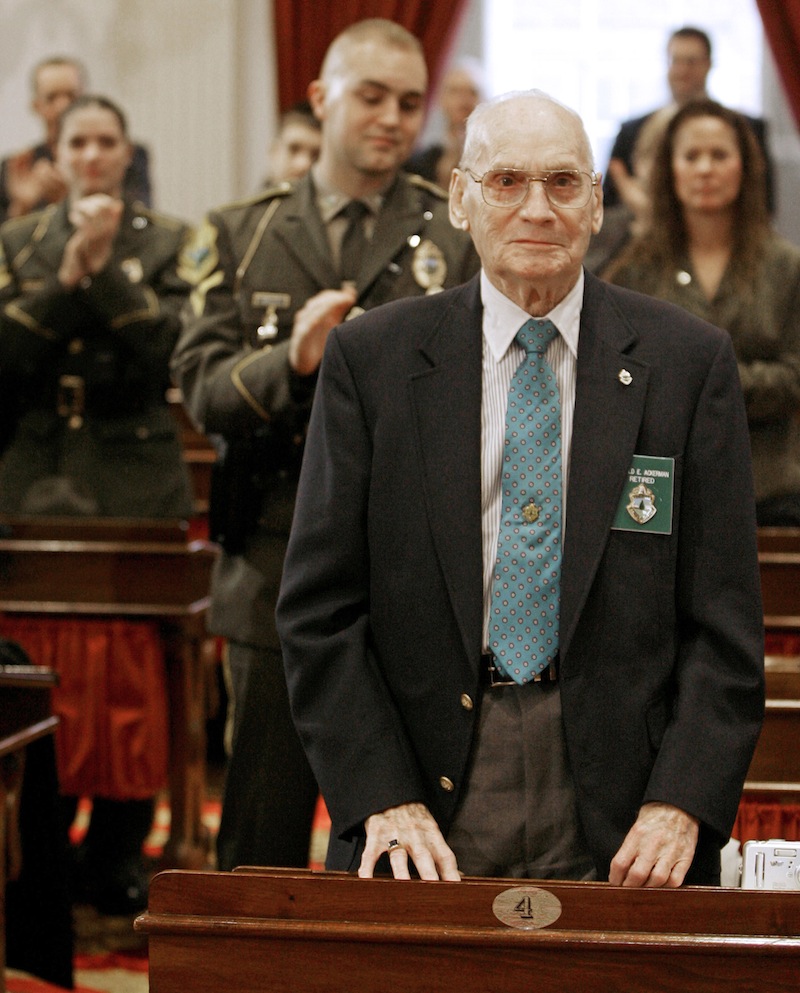 In this Dec. 15, 2006 file photo, former Vermont State Police Lt. Harold "Ace" Ackerman, 86, of St. Johnsbury, Vt. stands to be recognized during an awards ceremony at the Statehouse in Montpelier, Vt. The last surviving member of the original Vermont State Police has died. Ackerman died Monday at his home in St. Johnsbury. He was 92. The state police was formed after a 1946 search for a missing Bennington College student proved too complex for local authorities. Ackerman was one of the original troopers when the Vermont State Police was formed from the Department of Motor Vehicles' highway patrol. (AP Photo/Toby Talbot)