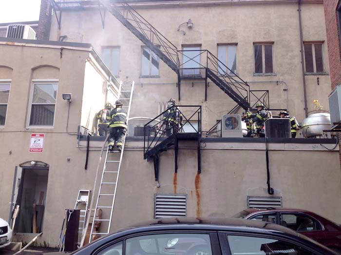 Portland firefighters check the back of 86 Exchange St. on Monday.