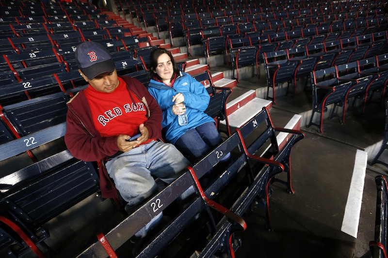 Paul Robinson, left, of Cambridge, Mass., and Madeline Jendzejec, of Somerville, Mass., wait for a baseball game between the Boston Red Sox and the Baltimore Orioles in Boston, Wednesday, April 10, 2013. The Red Sox's nearly 10-year streak of consecutive sold-out home games was expected to end on Wednesday. (AP Photo/Michael Dwyer)