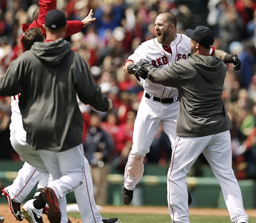 Boston Red Sox's Mike Napoli is mobbed by teammates after his game-winning double scored teammate Dustin Pedroia during the ninth inning of Boston's 3-2 win over the Tampa Bay Rays in a baseball game at Fenway Park in Boston on Monday, April 15, 2013. (AP Photo/Winslow Townson)