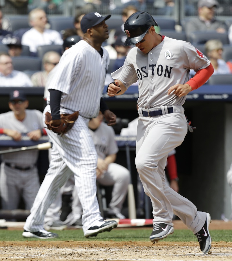 Boston Red Sox runner Jacoby Ellsbury, right, scores in front of New York Yankees starting pitcher CC Sabathia, left, on Dustin Pedroia's second-inning, RBI single in an Opening Day baseball game at Yankee Stadium in New York on Monday.