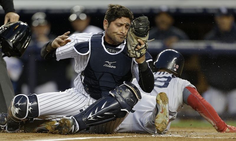 New York Yankees catcher Francisco Cervelli, left, reacts after tagging out Boston Red Sox Shane Victorino, right, who was trying to score on a wild pitch in the first inning of a baseball game at Yankee Stadium in New York on Thursday.