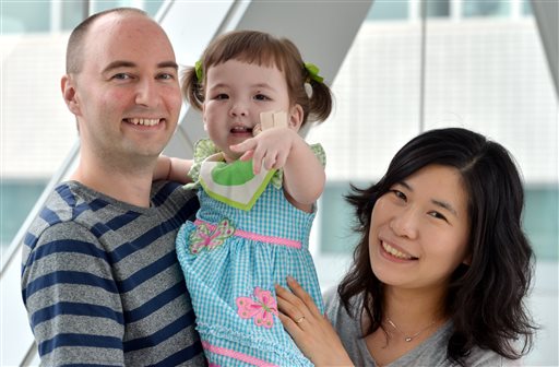 In this July 2012 photo, Hannah Warren poses with her parents Lee Young-mi and Darryl Warren at Seoul National University Hospital in Seoul, South Korea.