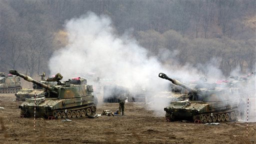 South Korean Marines' K-55 self-propelled howitzers are covered by smoke during a military exercise in the border city between two Koreas, Paju, north of Seoul, South Korea on Tuesday, as North Korea vows to restart a nuclear reactor that can make one bomb's worth of plutonium a year.