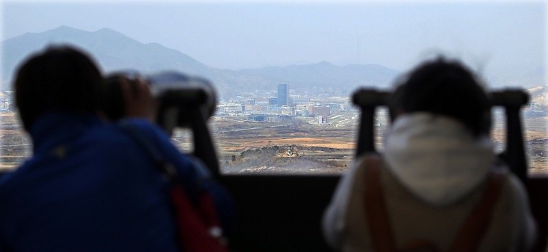 Visitors look at the North-South Korea industrial complex in Kaesong through binoculars at Dora Observation Post in the demilitarized zone (DMZ) near the border village of Panmunjom, Tuesday, April 9, 2013.The massive industrial park the rival Koreas have jointly run for nearly decade was a virtual ghost town Tuesday, its South Korean managers left to wander past shutdown assembly lines or stuff their cars to the brim with whatever goods would fit before heading south for the Demilitarized Zone that divides the nations. (AP Photo/Won Dae-hyun) Korea Out