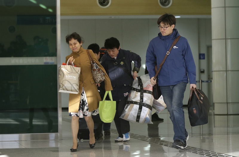 South Koreans arrive with their belongings from North Korea's Kaesong at the customs, immigration and quarantine office near the border village of Panmunjom, that has separated the two Koreas since the Korean War, in Paju, north of Seoul, South Korea, Tuesday, April 9, 2013. A few hundred South Korean managers, some wandering among quiet assembly lines, were all that remained Tuesday at the massive industrial park run by the rival Koreas after North Korea pulled its more than 50,000 workers from the complex. Others stuffed their cars full of goods before heading south across the Demilitarized Zone that divides the nations. (AP Photo/Lee Jin-man)