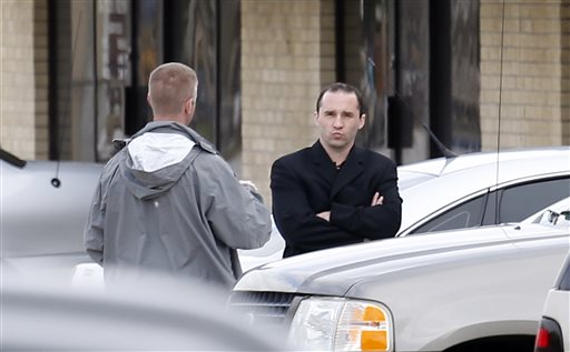 Everett Dutschke, right, confers with a federal agent on Wednesday near the site of a martial arts studio he once operated in Tupelo, Miss. The property was being searched in connection with the investigation into poisoned letters mailed to President Barack Obama and others. Dutschke has not been arrested or charged.