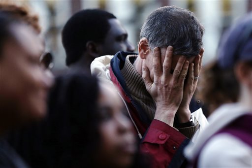 In this Wednesday photo, a mourner reacts during a candlelight vigil at City Hall in Cambridge, Mass. in the aftermath of Monday's Boston Marathon explosions.