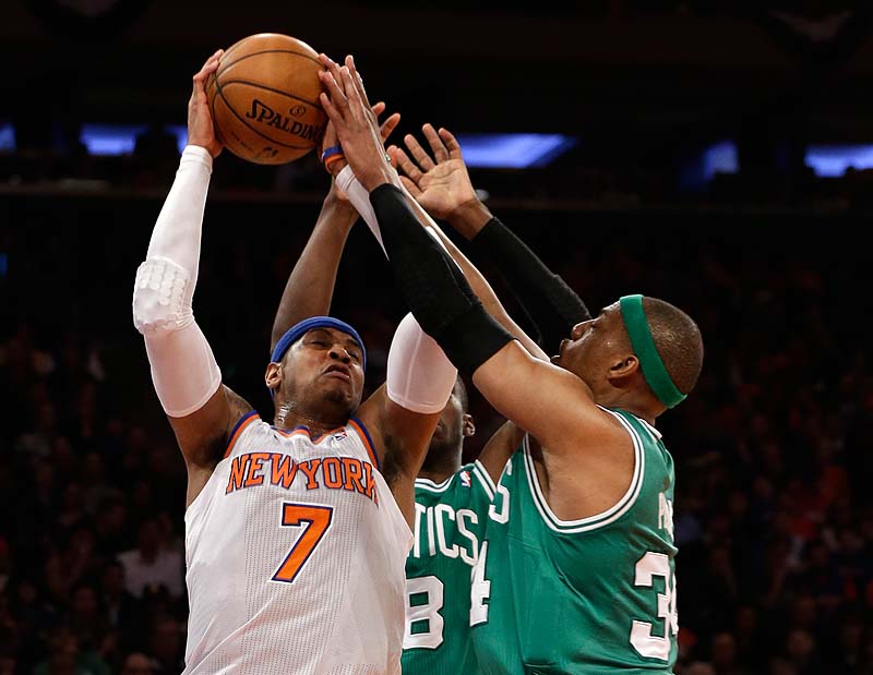 Carmelo Anthony of the Knicks fends off Boston's Jason Terry, 8, and Paul Pierce in the first half of Saturday's playoff game at New York.