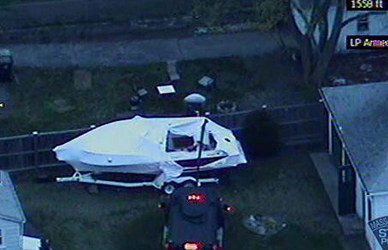This image made available by the Massachusetts State Police shows a police vehicle probing the boat where 19-year-old Boston Marathon bombing suspect Dzhokhar Tsarnaev was hiding in Watertown, Mass. He was pulled, wounded and bloody, from the boat parked in the backyard of a home in the Greater Boston area.