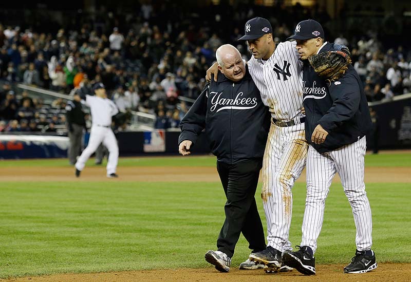 In this file photo, trainer Steve Donohue, left, and Yankees Manager Joe Girardi help Derek Jeter off the field after he breaks his ankle during Game 1 of the ALCS last October. Jeter has re-broken his ankle, according to the Yankees.