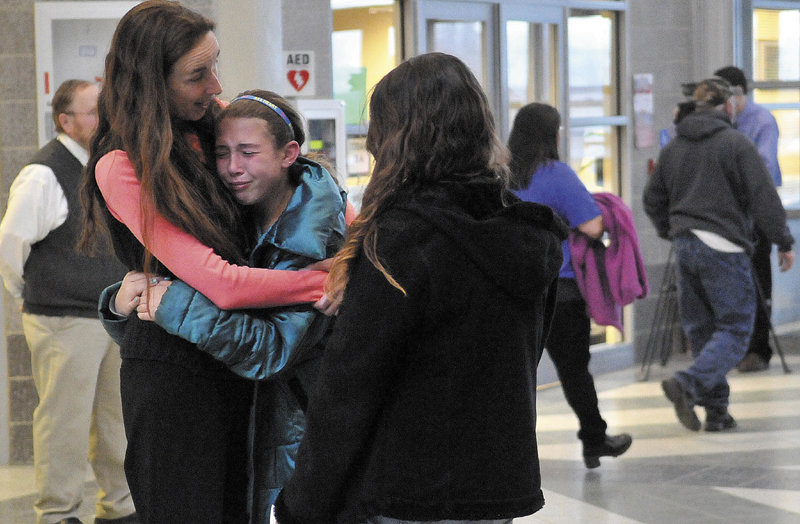 Deb McIntyre, left, comforts Katelin Lewis, 11, center, a sixth-grader at Mount View High School in the hall of Mount View High School following the Community Forum on suicide prevention and grieving on Thursday evening. The purpose of the forum is to provide information and resources about suicide and suicide prevention.