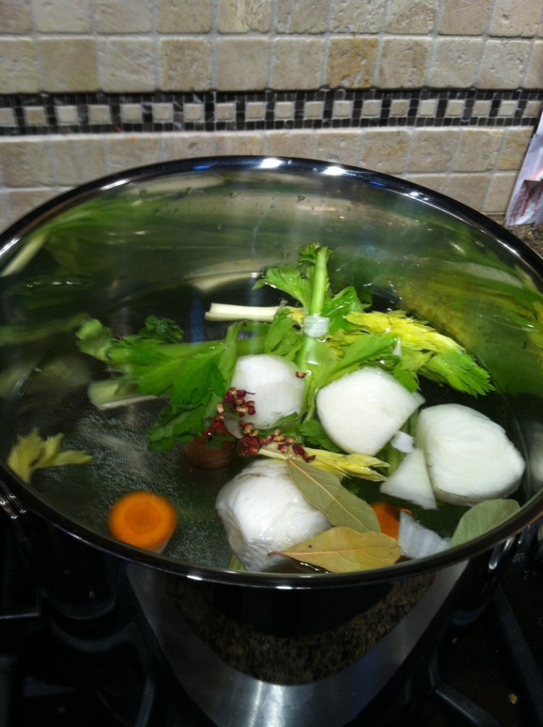Leftover vegetables and bones simmer in a stock pot.