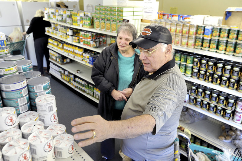 Volunteer George Coburn assists Eleanor Locey of Saco select groceries at the Saco Food Pantry last week.