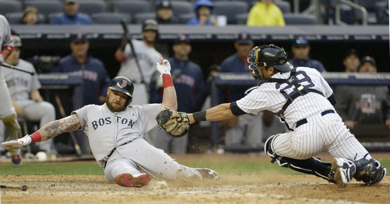 Boston's Jonny Gomes beats the tag of Yankees catcher Francisco Cervelli as he scores on a single by Jacoby Ellsbury in the ninth inning at New York.