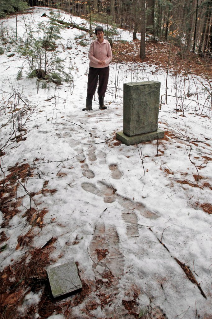 In this Thursday, March 28, 2013 photo, Rep. Anne Donahue looks at a memorial stone at the site of a Vermont State Hospital cemetery in Waterbury, Vt. Vermont mental health advocates are trying to decide what to do with the abandoned cemetery near the former State Hospital, which was forced to move by flooding from Tropical Storm Irene. (AP Photo/Toby Talbot)