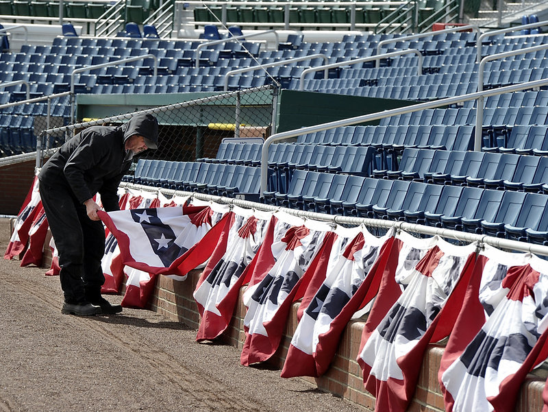 Rick Anderson, the head groundskeeper at Hadlock Field, adjusts bunting Tuesday as the Portland Sea Dogs prepare to open their season at 6 p.m. Thursday against the Trenton Thunder.