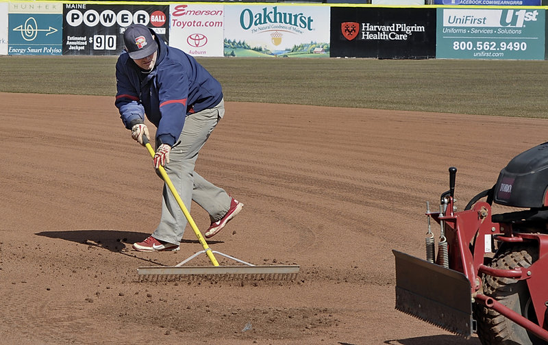The snow has been cleared, summer is on the way and Jason Cooke, the assistant head groundskeeper, works on the infield to prepare for the opener.