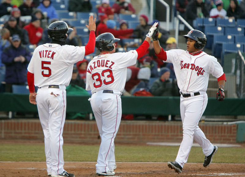Heiker Meneses, right, is congratulated by Christian Vazquez and Kolbrin Vitek after hitting a three-run homer Thursday night for the Portland Sea Dogs in the second inning of a 13-5 loss to Trenton to open the season.