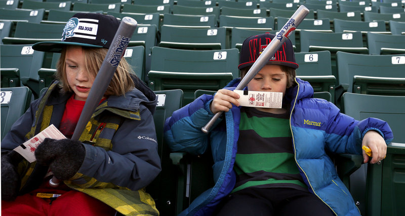 Otis and Eli Evans of Portland check their tickets as they settle in for the Sea Dogs season opener Thursday.