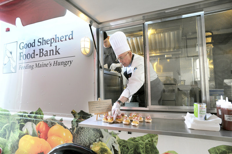 Wilfred Beriau, retired chair of the Southern Maine Communty College culinary department, serves appetizers from the Good Shepherd Food-Bank’s new food truck. The occasion was the food bank’s annual gala at its warehouse in Auburn, where the truck was christened by chefs Rob Evans, below left, and Karl Deuben.