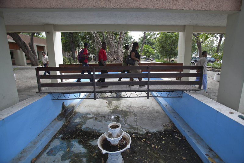People use a pedestrian bridge at the entrance to Haiti’s main courthouse, which was renovated by Chemonics International Inc., a for-profit firm based in Washington, D.C.