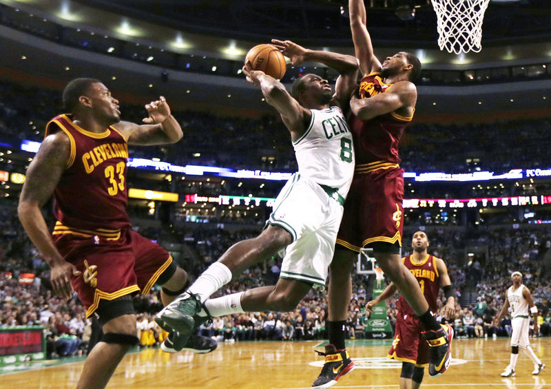 Boston Celtics forward Jeff Green (8) tries to get his shot off as he is pressured by Cleveland Cavaliers forward Tristan Thompson, right, in Boston Friday. At left is Cavaliers forward Alonzo Gee (33).