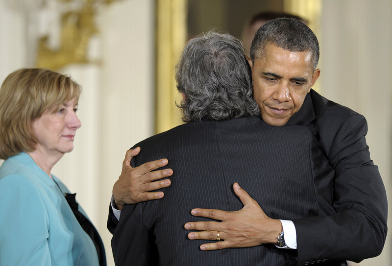 President Obama hugs Gilles Rousseau, father of slain Sandy Hook Elementary School teacher Lauren Rousseau, as her mother, Terry Rousseau, stands at left during a White House ceremony in Washington in February. Families of the school shooting victims have coalesced into a lobbying voice.