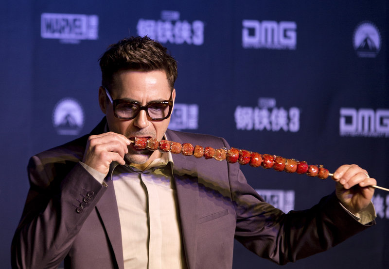 Robert Downey Jr. tries a Chinese snack at a Beijing hotel Saturday.