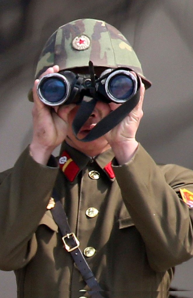 A North Korean soldier uses binoculars to watch the South Korean side at the border village of Panmunjom in the demilitarized zone.