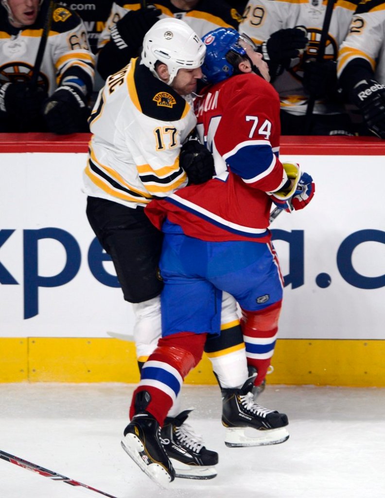 Milan Lucic of the Bruins checks Canadiens defenseman Alexei Emelin from behind Saturday night during Montreal’s 2-1 victory at home.