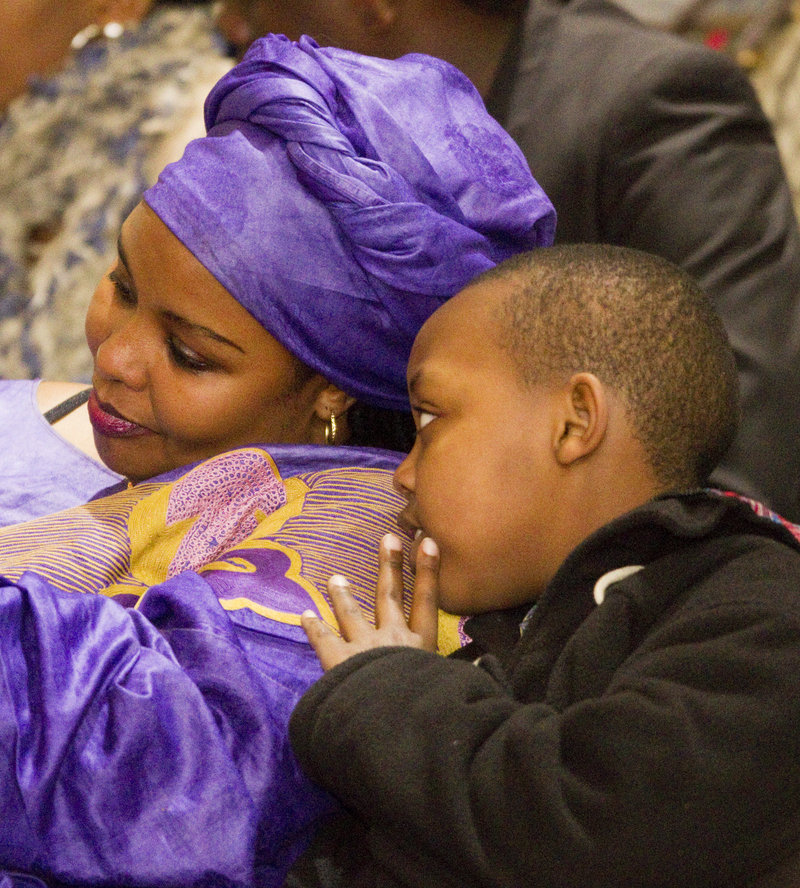 Daniel Bizimana whispers to his mother, Francoise Nsengiyumva, during a ceremony in Portland Sunday.