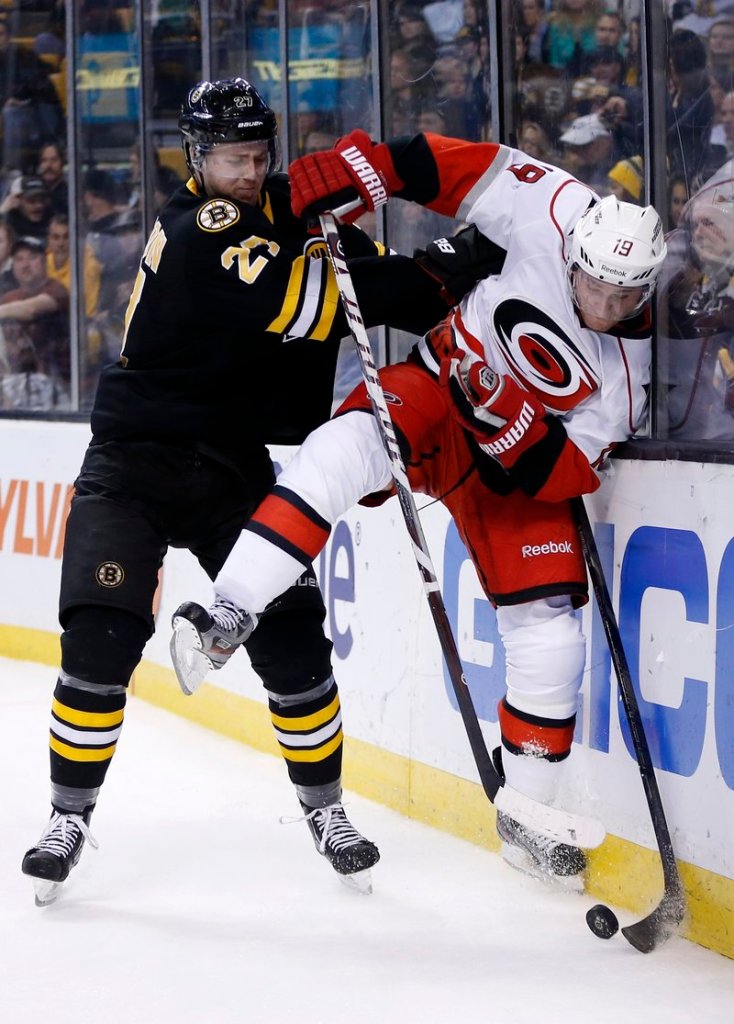 Dougie Hamilton of the Bruins slams Carolina’s Jiri Tlusty into the boards Monday night in Boston. The Bruins scored a season-high six goals in beating the Hurricanes.