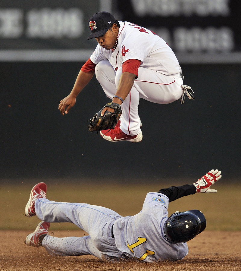Heiker Meneses of the Sea Dogs leaps over Reading’s Derrick Mitchell, who broke up a double play in the fifth inning Tuesday night at Hadlock Field.