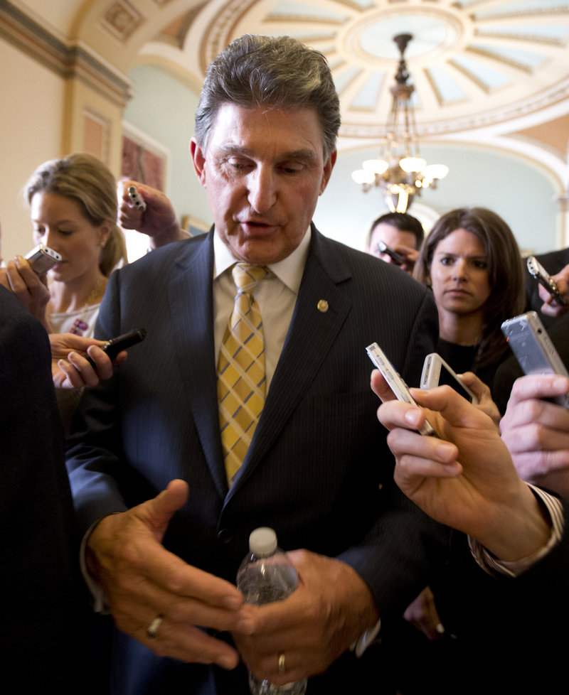 Sen. Joe Manchin, D-W.Va., answers reporters' questions as he leaves the office of Senate Majority Leader Harry Reid, D-Nev., on Capitol Hill in Washington, Tuesday, April 9, 2013, after a meeting on gun control. Reid's determination to stage a vote came despite continued inconclusive talks between Manchin, Sen. Patrick Toomey, R-Pa., aimed at finding compromise on expanding background checks to more gun purchasers. But Manchin left a meeting in Reid’s office late Tuesday and said he hoped a deal could be completed on Wednesday. (AP Photo/Manuel Balce Ceneta)