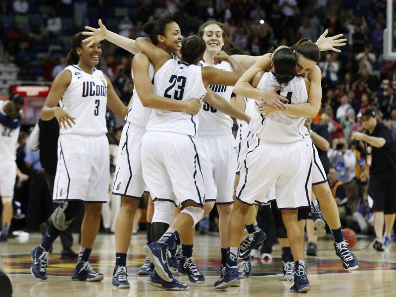 Connecticut players celebrate after defeating Louisville 93-60 for the national women’s basketball championship Tuesday in New Orleans. UConn is now tied with Tennessee for the most titles, eight.