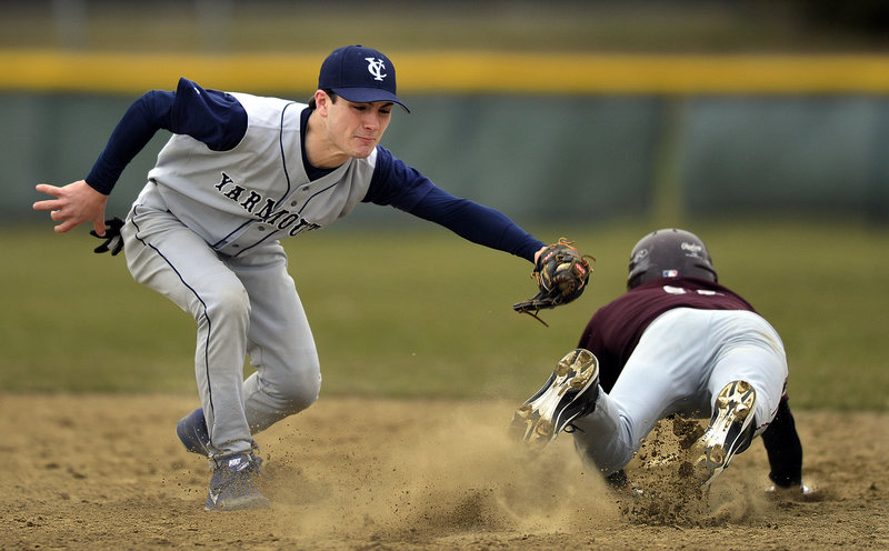 Jack Davenport of Freeport dives in an attempt to avoid a tag by Yarmouth second baseman Kevin Haley during Yarmouth’s 5-2 victory Thursday in a high school baseball opener.