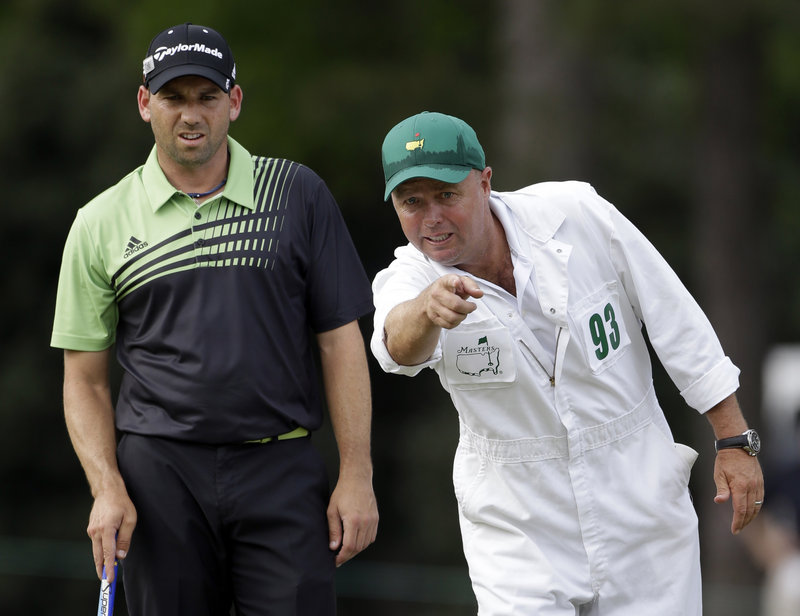 Sergio Garcia, who doubted last year he ever could win a Masters, listens to his caddie, Greg Hearmon, during his first-round 66 on Thursday. Garcia is tied for the lead.