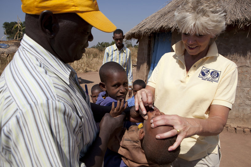 Ann Lee Hussey administers the polio vaccine to a child in Chad during one of her 25 trips overseas with Rotary International. Each child receives two drops of the oral vaccine. Hussey contracted the disease when she was a child.